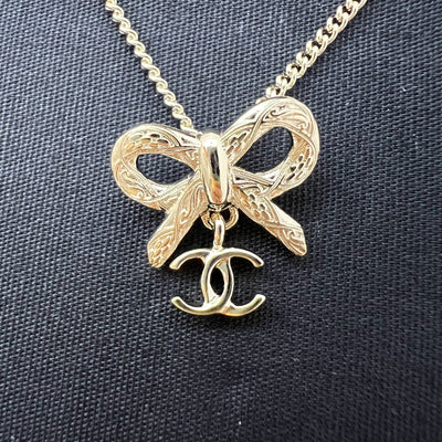 Chanel 25K Bow and Dangling Logo Necklace in SHW (Model: ABG556)