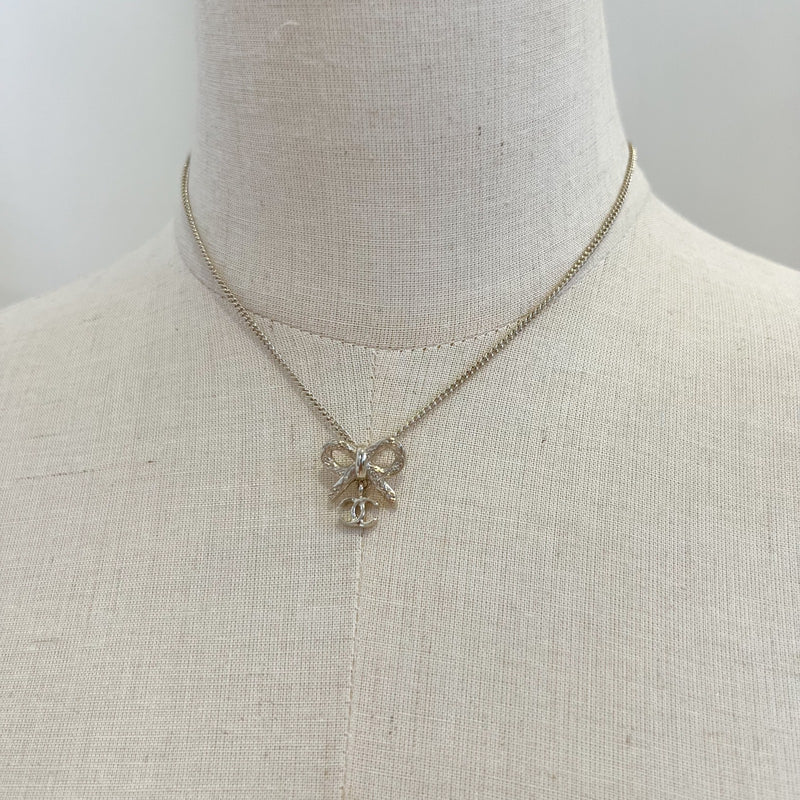 Chanel 25K Bow and Dangling Logo Necklace in SHW (Model: ABG556)